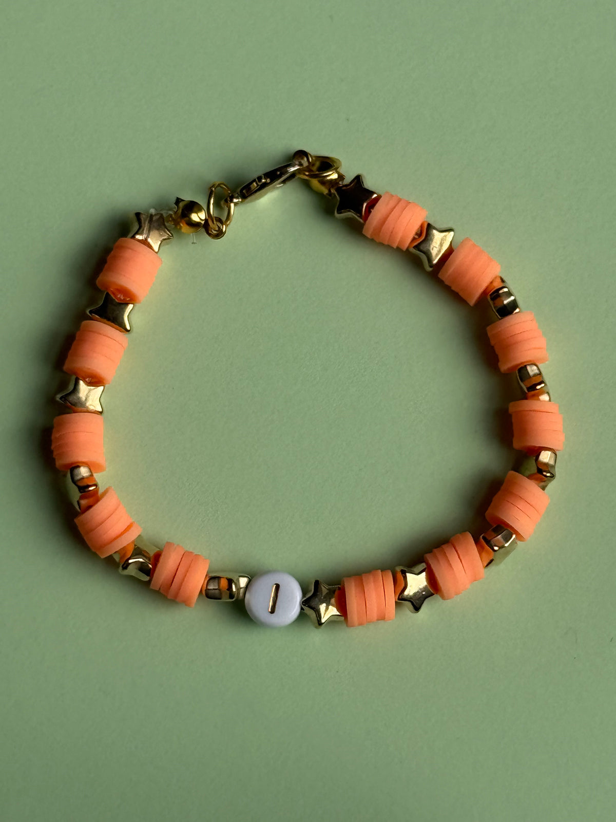 Orange lettered bracelet with a 'J' size 17.5cm