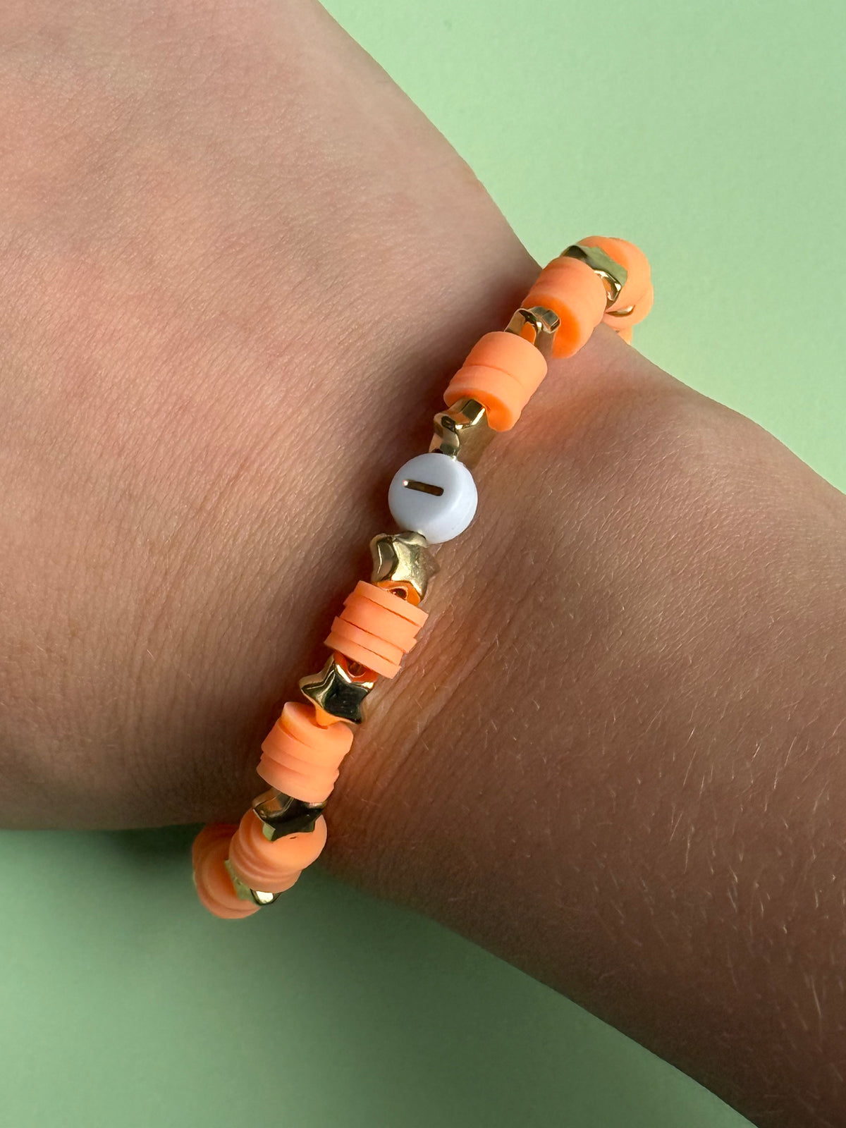Orange lettered bracelet with a 'J' size 17.5cm