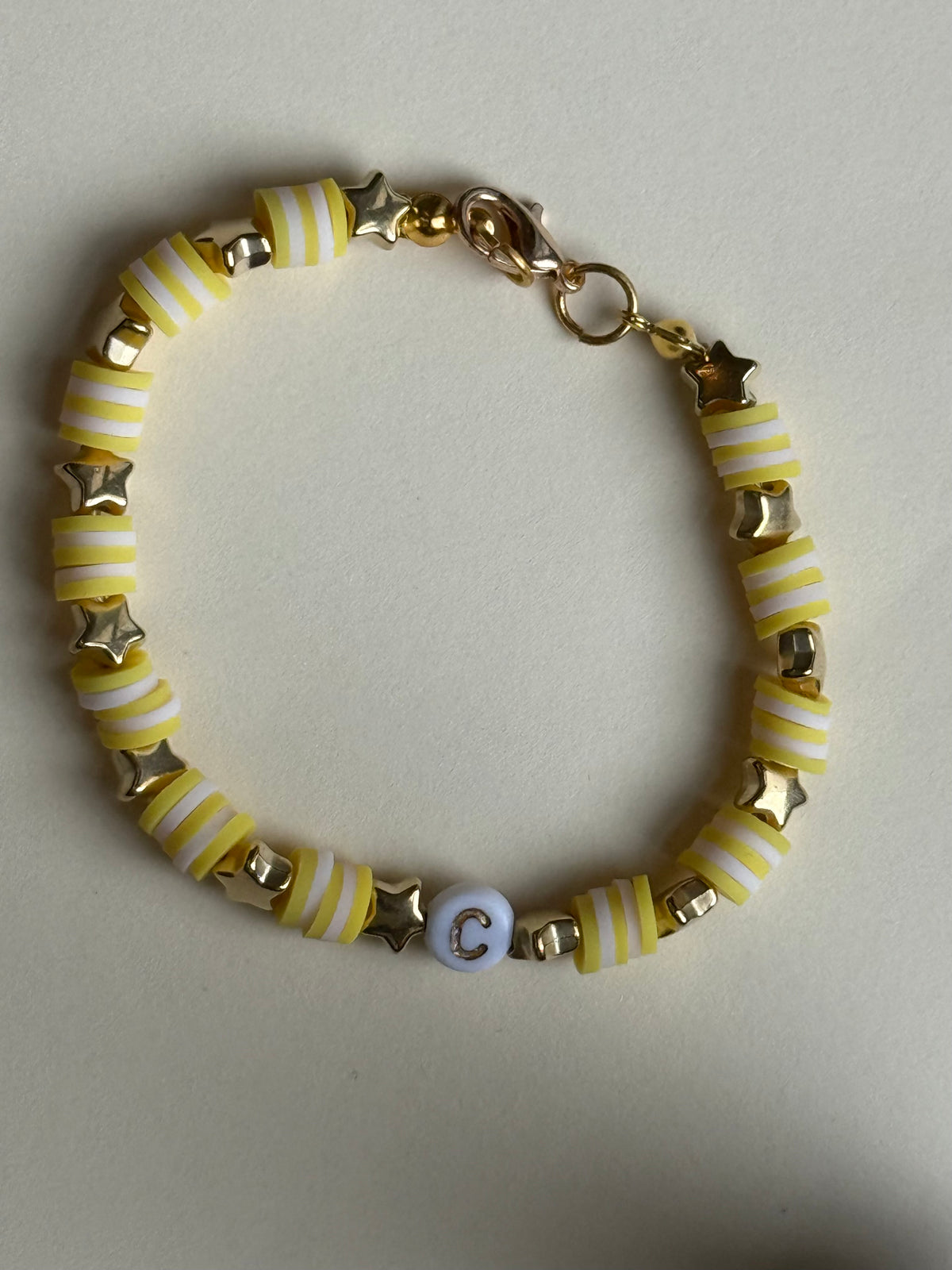 Yellow and white lettered bracelet with a 'C' size 17cm